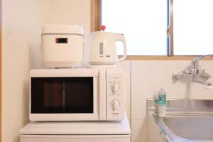 eine weiße Mikrowelle auf einer Theke in der Unterkunft 3 min JR Direct to Skytree Asakusa Shinjuku Sea Heim in Tokio + 40 Fotos