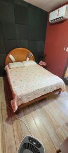 een bed in een kamer met een ventilator op de vloer bij Casa térrea a 1km da praia com ar condicionado in Bertioga