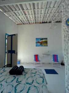 een slaapkamer met een bed, twee stoelen en een kruis bij Solar da Pérola in Salvaterra