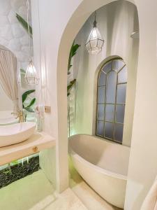 ein Badezimmer mit Badewanne und Waschbecken in der Unterkunft Staycationku Premium Jogja Villas in Beran-kidul