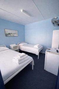 twee bedden in een kamer met blauwe muren bij Zen Hostel in Townsville +13 foto's