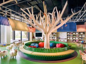 a tree in the middle of a room with animals at Mövenpick Resort Al Marjan Island in Ras al Khaimah