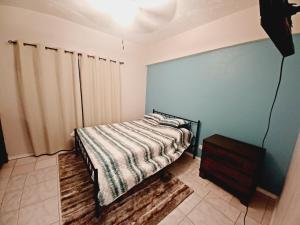 a bedroom with a bed and a blue wall at Chill on Cassi Hill in Nazareth
