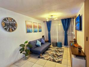 a living room with a couch and a clock on the wall at Oceanfront Vacation Pool WiFi Parking in Coquimbo