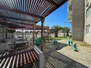 a wooden bench under awning next to a building at Oceanfront Vacation Pool WiFi Parking in Coquimbo