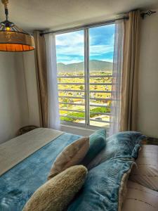 a bedroom with a bed with a large window at Oceanfront Vacation Pool WiFi Parking in Coquimbo +35 photos