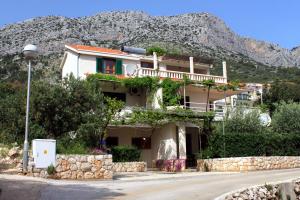 ein Haus auf einem Hügel mit einem Berg im Hintergrund in der Unterkunft Apartments with parking space Ivan Dolac, Hvar - 592 in Ivan Dolac