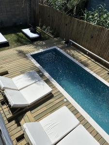 a swimming pool on a wooden deck next to a wooden fence at Pedre Loft in La Pedrera