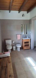 une salle de bain avec un lavabo et des toilettes et un lavabo dans l'établissement Cabañas Don Ricardo, à Dolores 1 autre photo