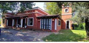 a red brick house with a tree in front of it at La Gloria in Paso de la Patria
