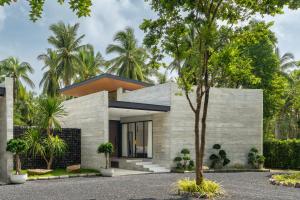 een modern huis met een boom ervoor bij Balance Village in Ko Phangan
