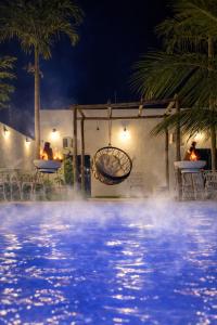 une piscine la nuit dans une station balnéaire dans l'établissement A Casa Paradisíaca ll Luxo Piscina Super Quente até 50 graus Aquecimento Elétrico e Solar Casa com Sauna a Vapor e Ar Condicionado em Todos Ambientes e Lavanderia com Roupa de Cama e Banho e Ofurô Super Quente , Temos Lareira , Com Valores adicionais, à Caldas Novas