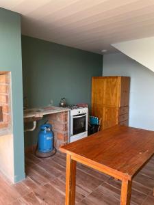 a kitchen with a wooden table and a stove at LaMora Quinta privada con pileta en Olavarría - cerca de Estudiantes in Olavarría +31 photos