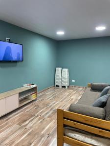a living room with a couch and a flat screen tv at LaMora Quinta privada con pileta en Olavarría - cerca de Estudiantes in Olavarría