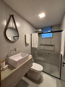 een badkamer met een toilet, een wastafel en een douche bij Flat com vista mar in Mucuri +2 foto's