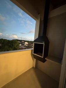 een televisie aan de zijkant van een muur met een raam bij Flat com vista mar in Mucuri