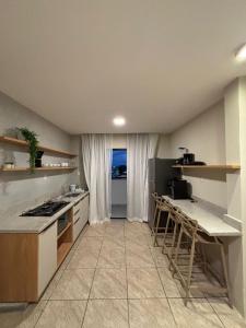 een keuken met een aanrecht, een tafel en stoelen bij Flat com vista mar in Mucuri