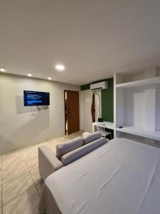 een slaapkamer met twee bedden en een tv aan de muur bij Flat com vista mar in Mucuri