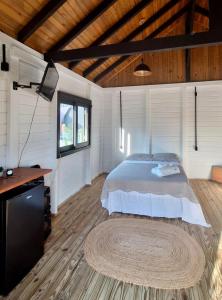 a bedroom with a bed and a television in it at Novidade-Cabana Praia do Rosa in Imbituba