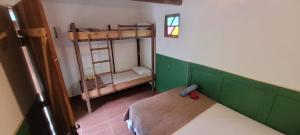 a small room with a bunk bed and a bench at Do Alto da Montanha Pousada in Vale do Capao