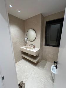 une salle de bains avec un lavabo et un miroir dans l'établissement Tirana Square Apartments, à Tirana