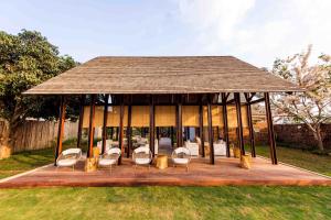 北冲Roukh Kiri Khaoyai, The Centara Collection的凉亭配有白色的椅子和桌子