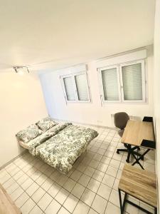 a bedroom with a bed and a table and chairs at Studio Cosy proche CHU in Amiens