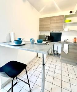 a kitchen with a counter with blue bowls on it at Studio Cosy proche CHU in Amiens