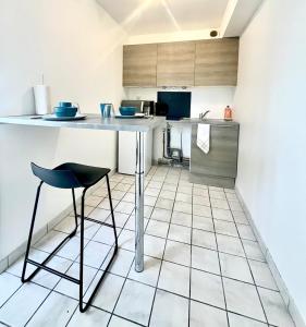 a kitchen with a counter and a table and stool at Studio Cosy proche CHU in Amiens
