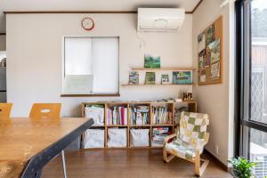 a dining room with a table and chairs and a book shelf at Blodge Lodge in Wazuka