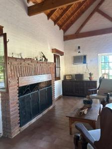 een woonkamer met een stenen open haard en een tafel bij La Dorada Inn in Luján
