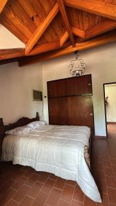 een slaapkamer met een groot bed met een houten hoofdeinde bij La Dorada Inn in Luján +4 foto's