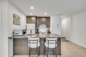 eine Küche mit einer großen Theke mit Hockern darin in der Unterkunft INITIAL - CAMPAGNARD - Chutes-Montmorency in Boischâtel