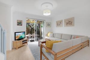 un soggiorno con un divano e una TV di Myralla a Point Lookout