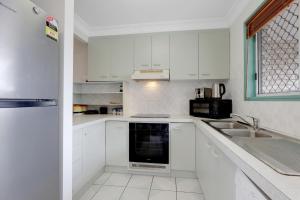 una cucina bianca con lavandino e lavastoviglie di Myralla a Point Lookout Altre 6 foto