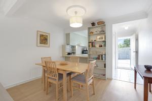 una cucina e una sala da pranzo con tavolo e sedie in legno di Myralla a Point Lookout