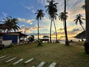 een uitzicht op een strand met palmbomen en een gebouw bij Redang Divers Resort in Redang Island