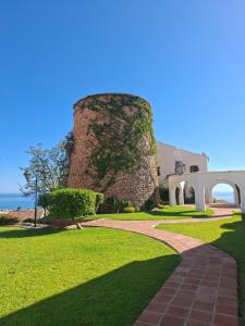 a brick walkway in front of a building with a tower at CASA PERSEA in Nerja