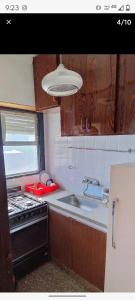 une petite cuisine avec un évier et une cuisinière dans l'établissement Departamento centrico, à Termas de Río Hondo