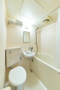 a bathroom with a toilet and a sink and a tub at Maison Junes 21 in Tokyo