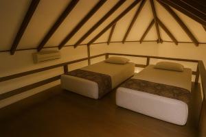 twee bedden in een kamer met houten vloeren bij Redang Divers Resort in Redang Island