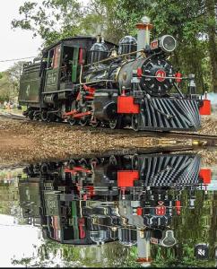een weerspiegeling van een trein in het water bij Pouso C&L in Tiradentes