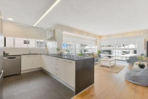 een keuken met witte kasten en een woonkamer bij Bel R Vista in Gold Coast