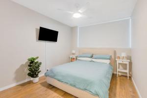 een slaapkamer met een bed en een flatscreen-tv bij Bel R Vista in Gold Coast