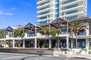 een groot gebouw met palmbomen voor een straat bij Bel R Vista in Gold Coast