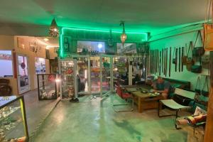 un homme assis à une table dans un magasin dans l'établissement Sleep Whale Lanta, à Ko Lanta