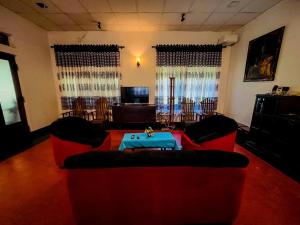 a living room with two couches and a table at Mango Three Resort in Anuradhapura