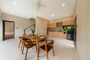 a dining room with a wooden table and chairs at Uma Dauh Villa - Cemagi in Munggu