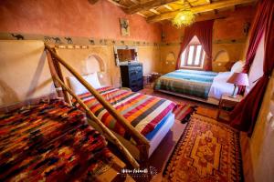a bedroom with a bed and a window and a rug at Kasbah ben Ali in El Kelaa des Mgouna +166 photos