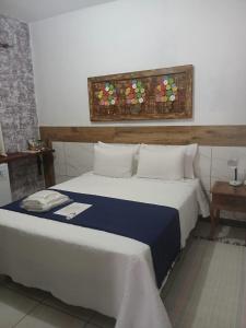 een slaapkamer met een groot bed met een blauw dekbed bij Pouso C&L in Tiradentes